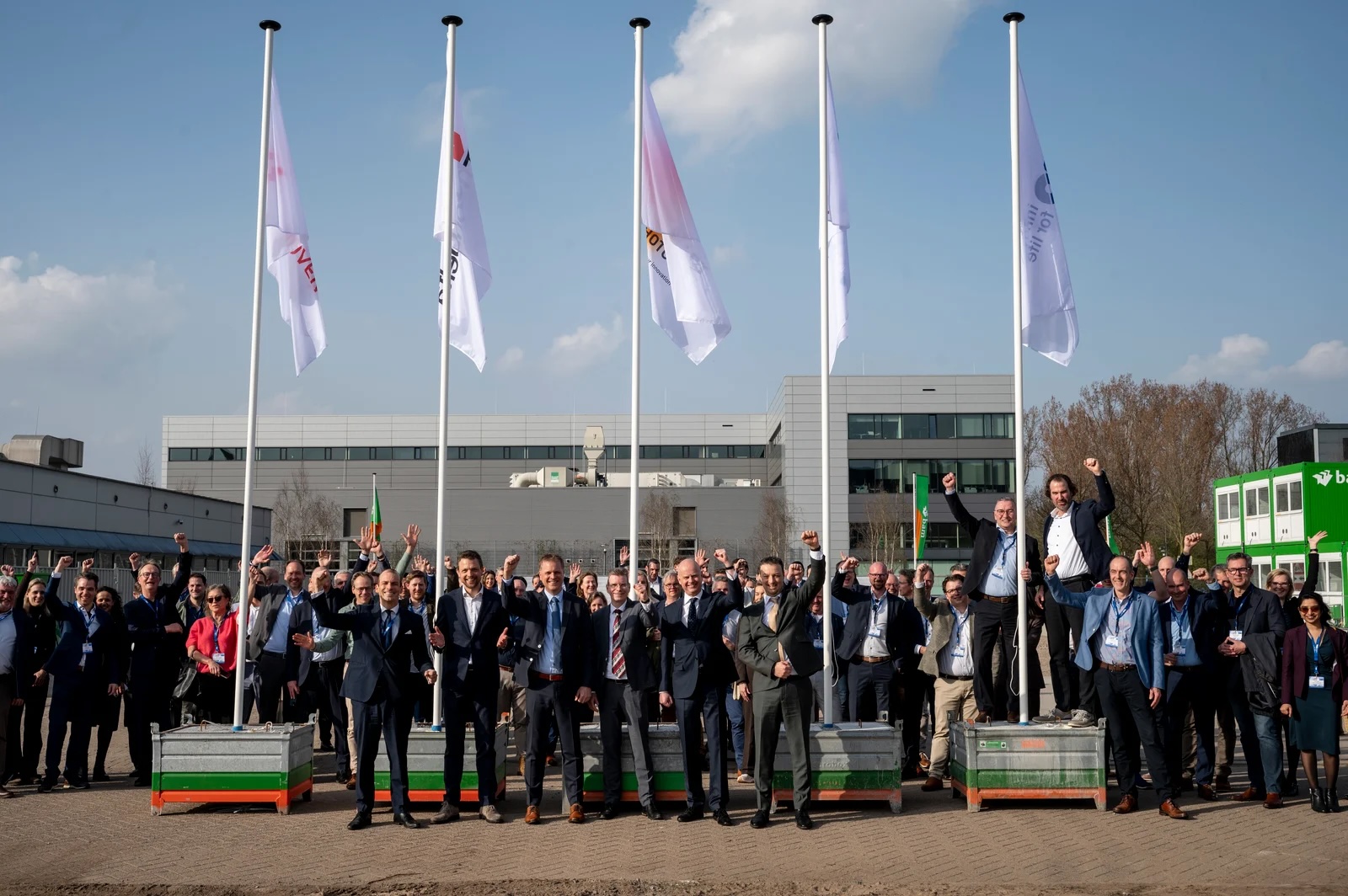 TNO, HTCE and government officials raise flags at construction launch.