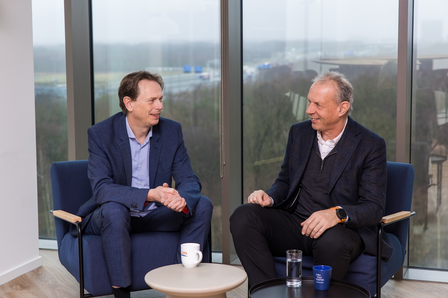 Two men sitting on a balcony at an office building