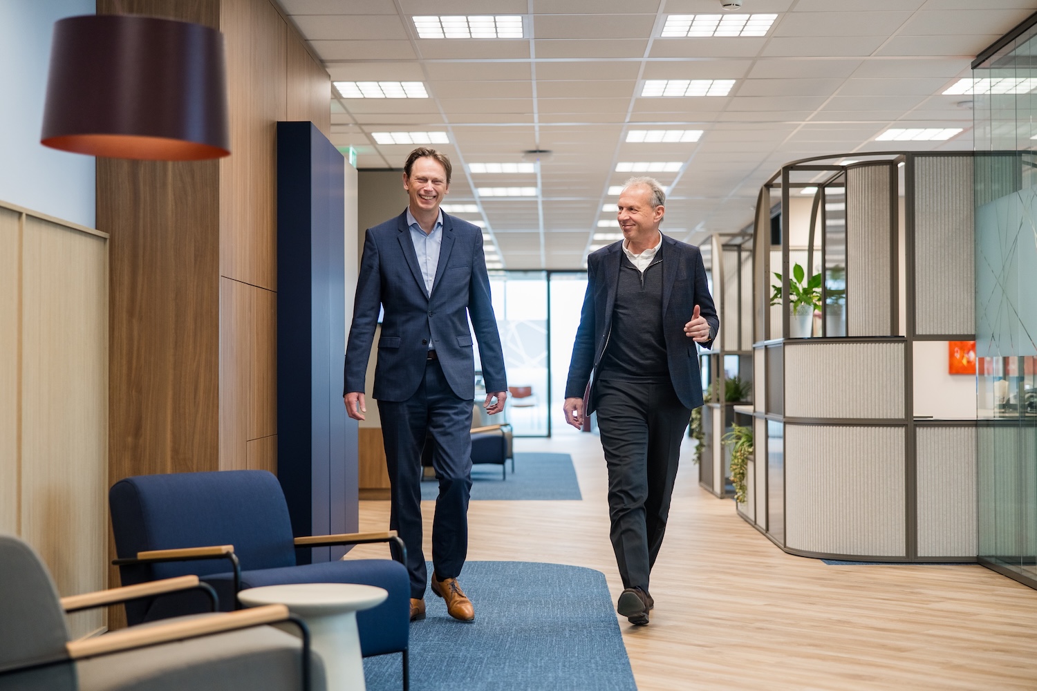 Two men walking in an open office