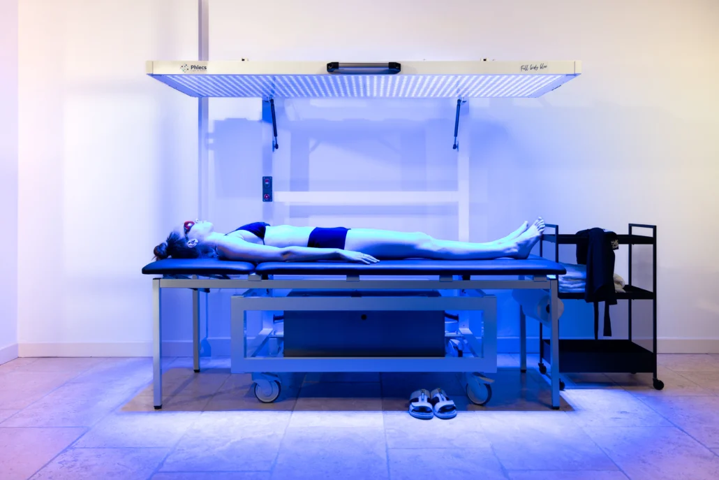 A woman lying under a blue light