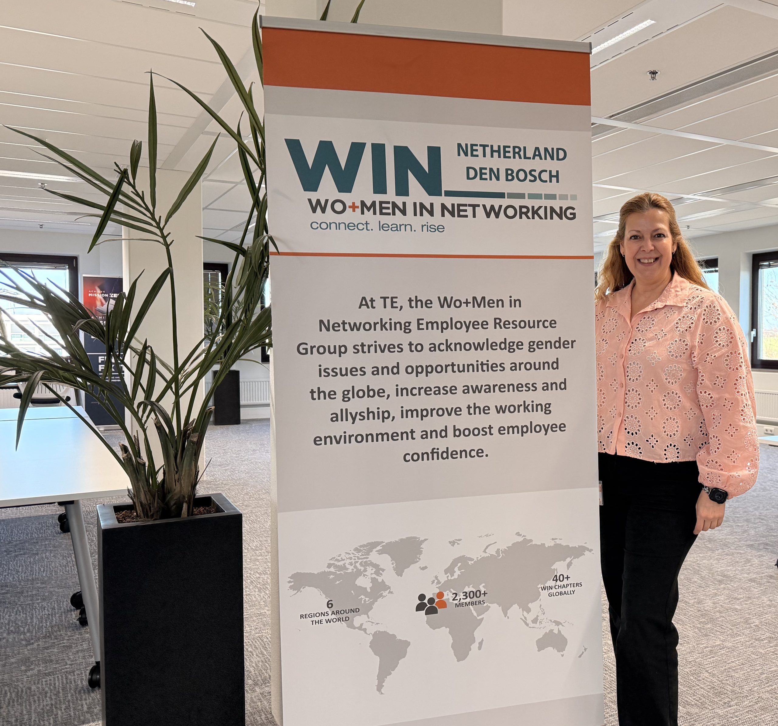 A woman standing in front of a banner